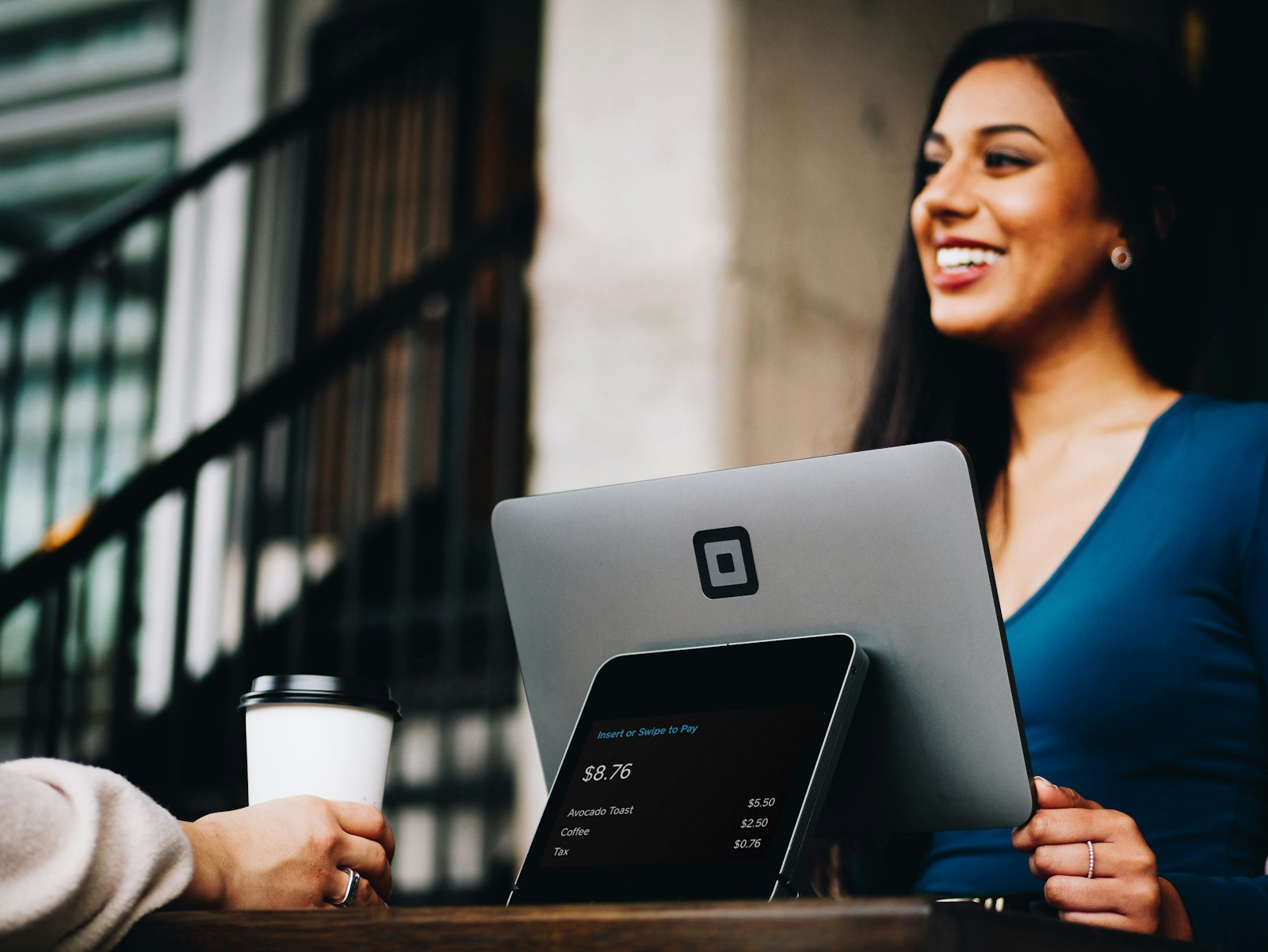 Business owner using a payment terminal during a sales conversation